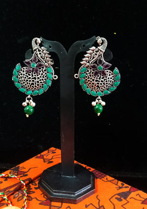 Silver oxidized earrings with green ruby studded and exclusive silver work for a stunning and stylish look.