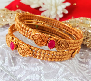 B035_Elegant Gold plated bangle with delicate work studded with pink ruby stones.