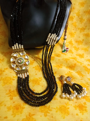 Pleasing and graceful necklace laden with exquisite work of black colored crystals, beautiful high quality pearls and Kundans