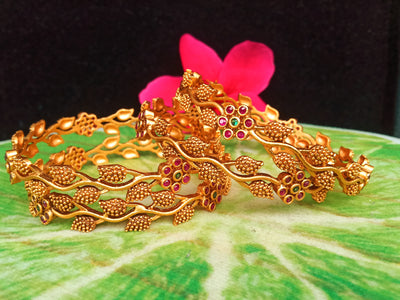 B036_Classy Gold plated bangles with flowery pattern embellished with pink and green ruby stones.