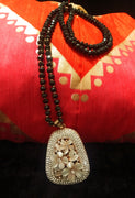 N0260_Gorgeous  Long Crystal bead necklace with a large pendant studded with semi precious stones with flower designs.