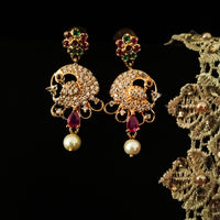 E0667_Beautiful crafted peacock design earrings studded with American diamond stones with a touch of pink & green stones with pearl drops.