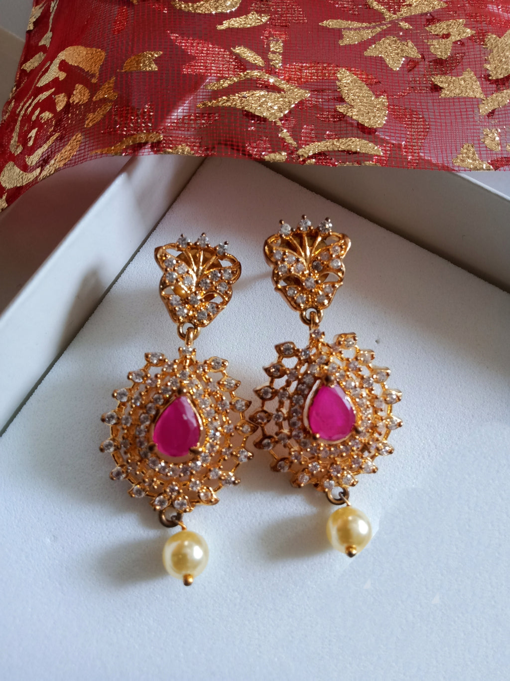 E0647_Gorgeous crafted design danglers studded with american diamond stones with a touch of pink ruby stones with a pearl drop.