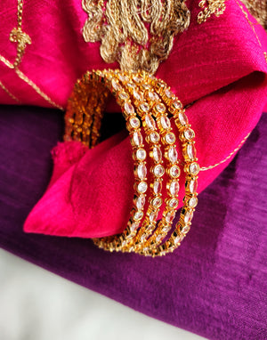 B0268_Classy sleek Gold plated bangles studded with  American Diamond  stones with delicate stone work.