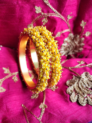 B0273_Lovely golden pearl bangles with delicate craftwork embellished with a bunch of yellow beads.